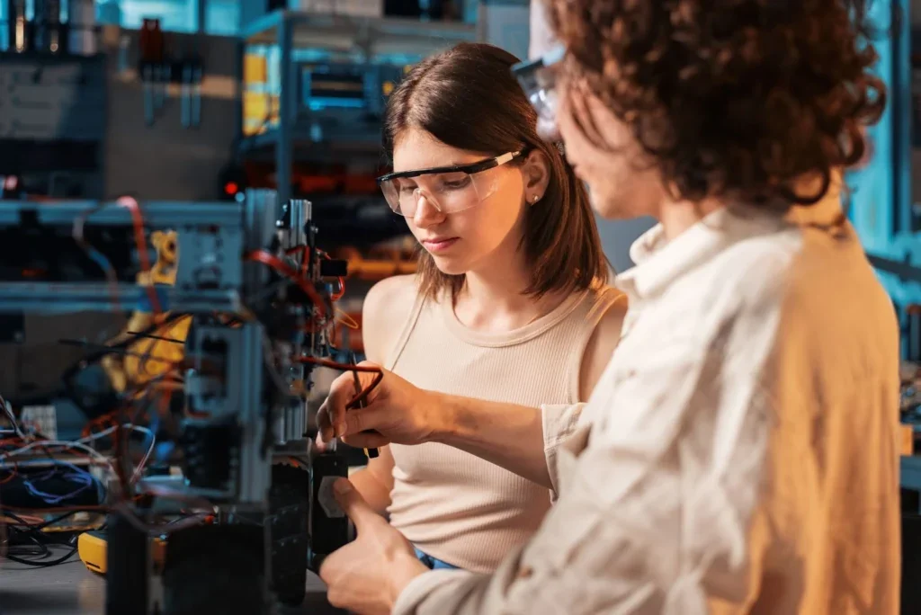 Dos profesionistas dentro de una fábrica industrial revisando una máquina.