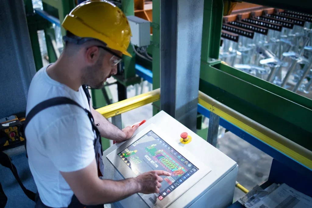 Ingeniero frente a una máquina que opera en una tableta.
