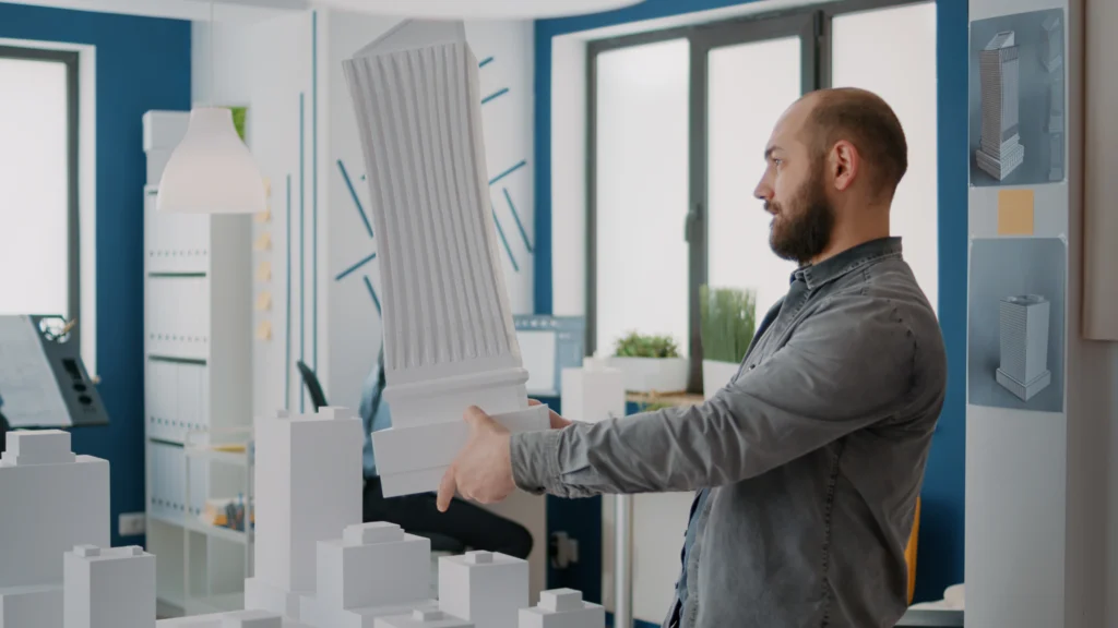 Arquitecto que sostiene un edificio hecho por impresión 3D.