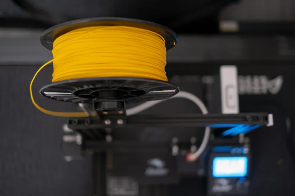Filamento amarillo posicionado para impresión 3D.
